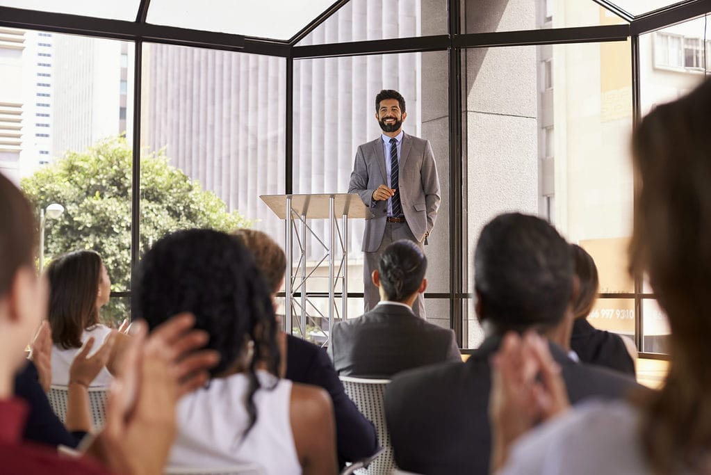 man in front of small crowd speaking, author speaker